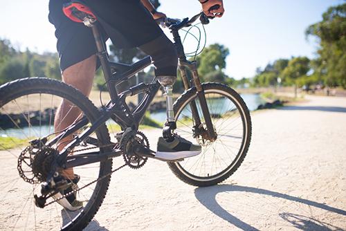 Amputee with fake leg on mountain bike.