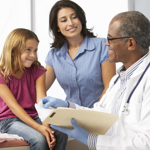 Young girl mother smiling at her doctor during a routine visit.