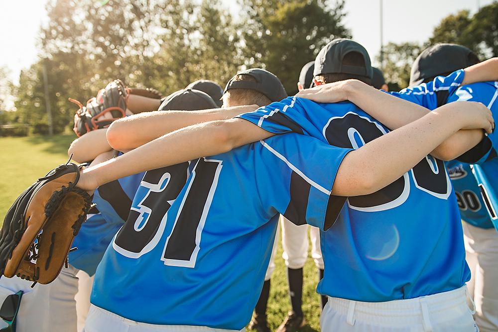 Teen baseball team in a huddle.