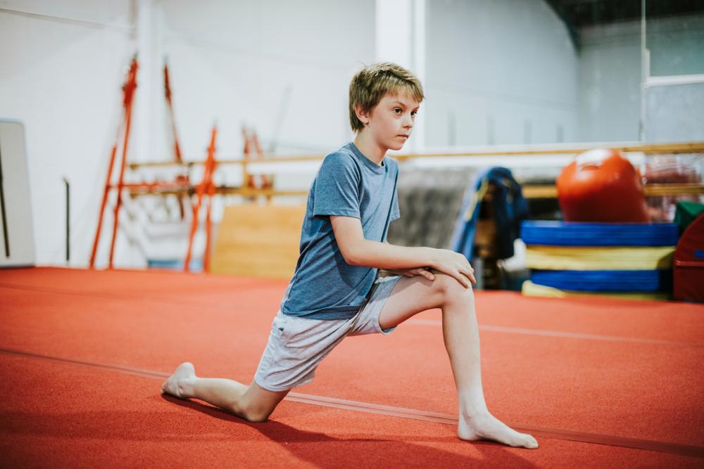 Young boy stretching before gymnastics.