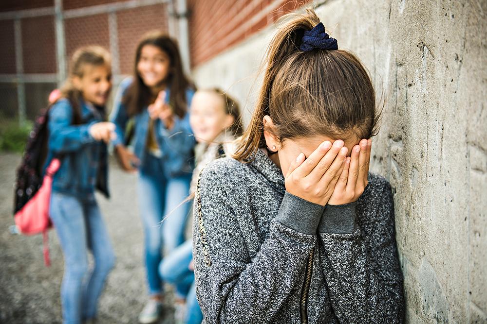 Young girl being bullied by three other girls.