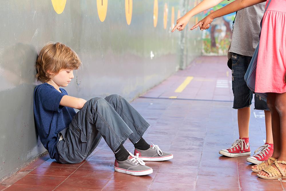 Young boy being bullied by two other kids.