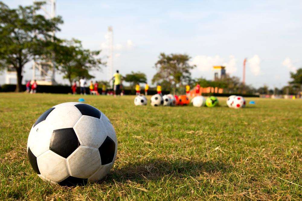 Close up of soccer ball with young athletes in background practicing.