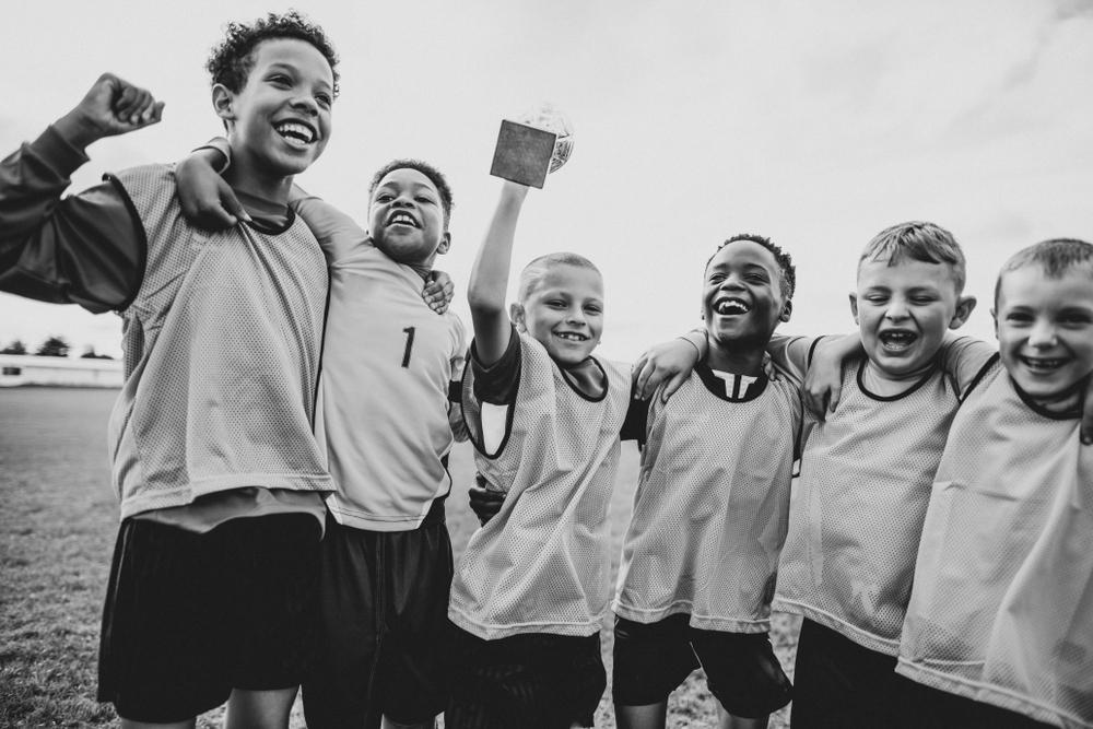 Diverse team of kids celebrating after sports game.