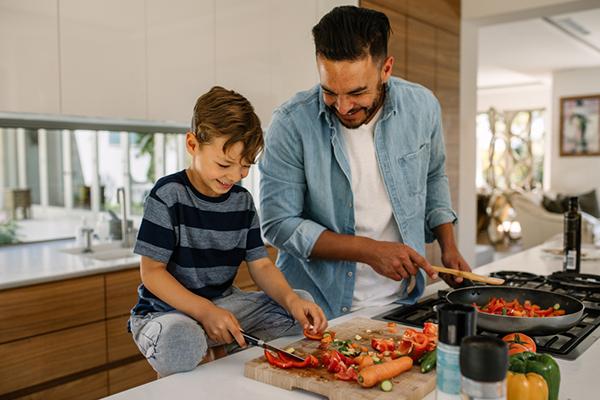 Father and son cooking in the kitchen.