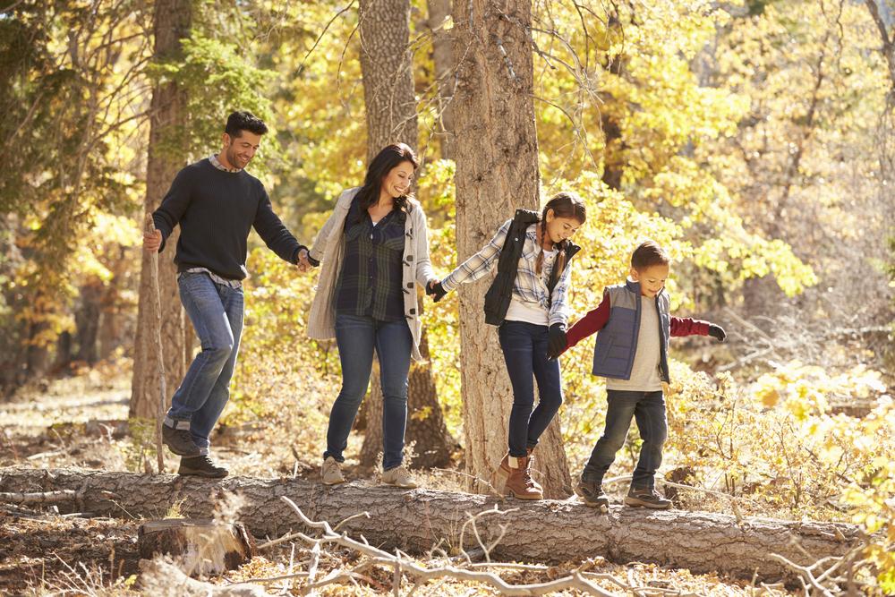 Hispanic family of four hiking in the woods.