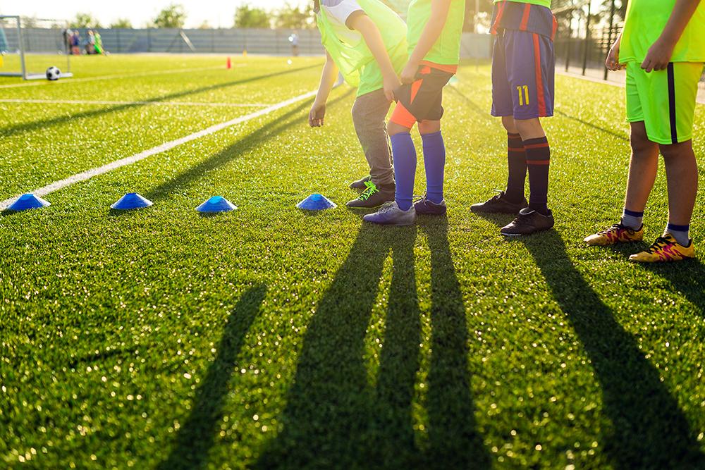 Soccer players shot from waist down about to begin training.