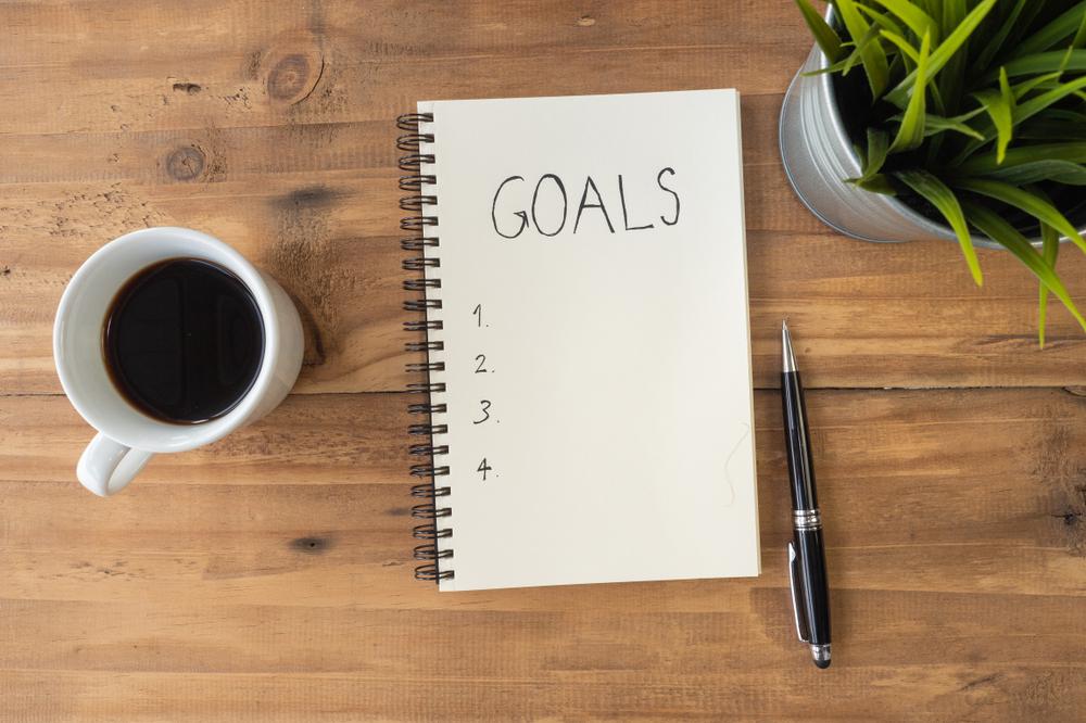 Notebook with "goals" written at the top next to a pen.