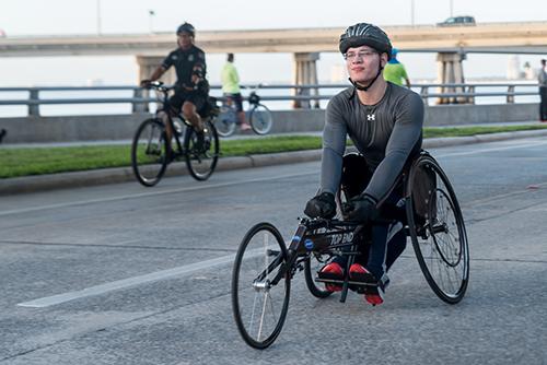 Young man in a hand cycle.