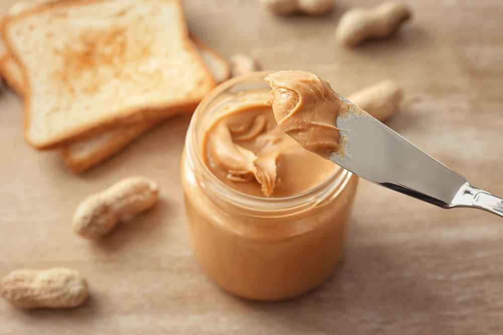 Knife taking peanut butter out of the jar.