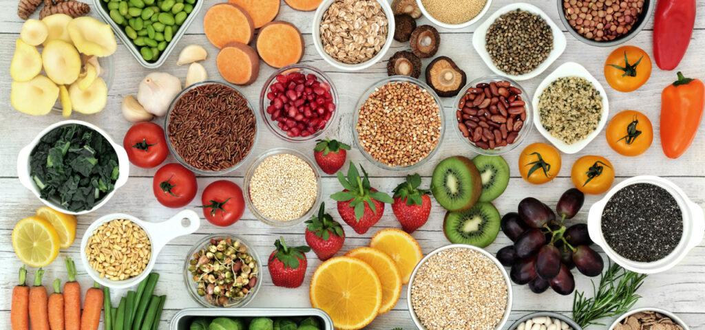 Variety of fruits, vegetables, grains, and nuts on a wood table.