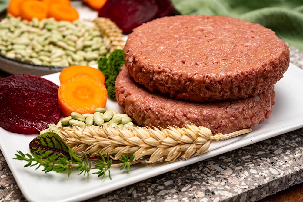 Vegan burgers next to grain and plants.