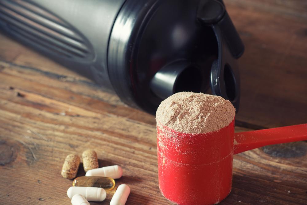 Powerdered supplement next to a water bottle.