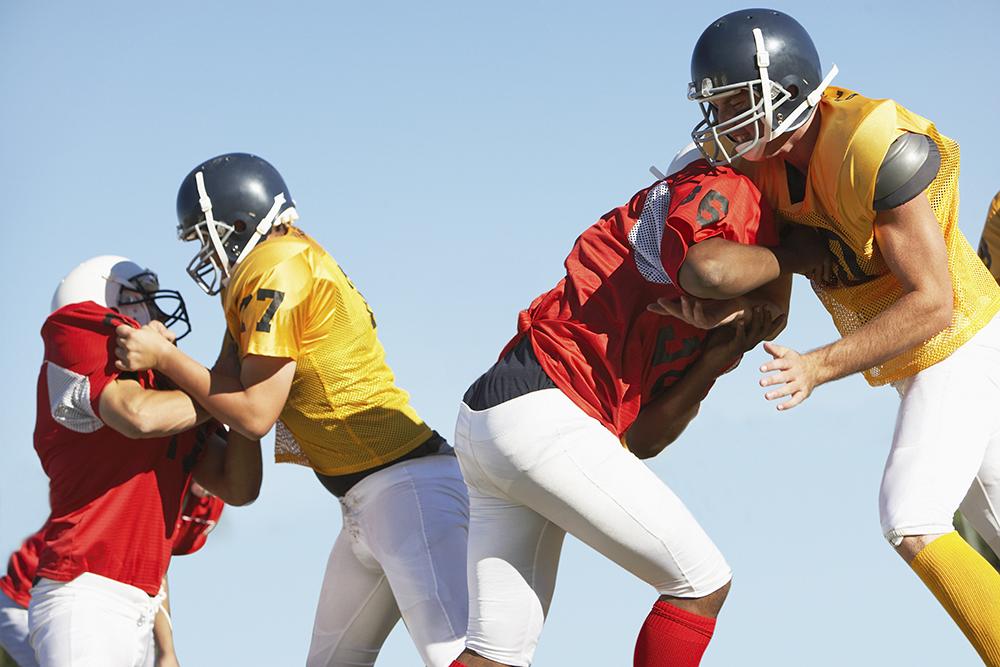 Football players clashing on the field.