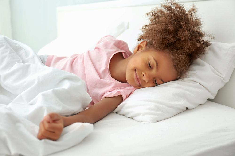 Young black girl happily sleeping.