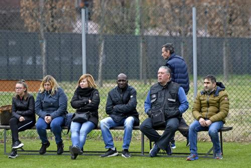 Parents on the sideline of an outdoors sports game.