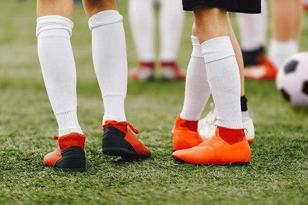 Close up of the tall socks worn by two young soccer players.