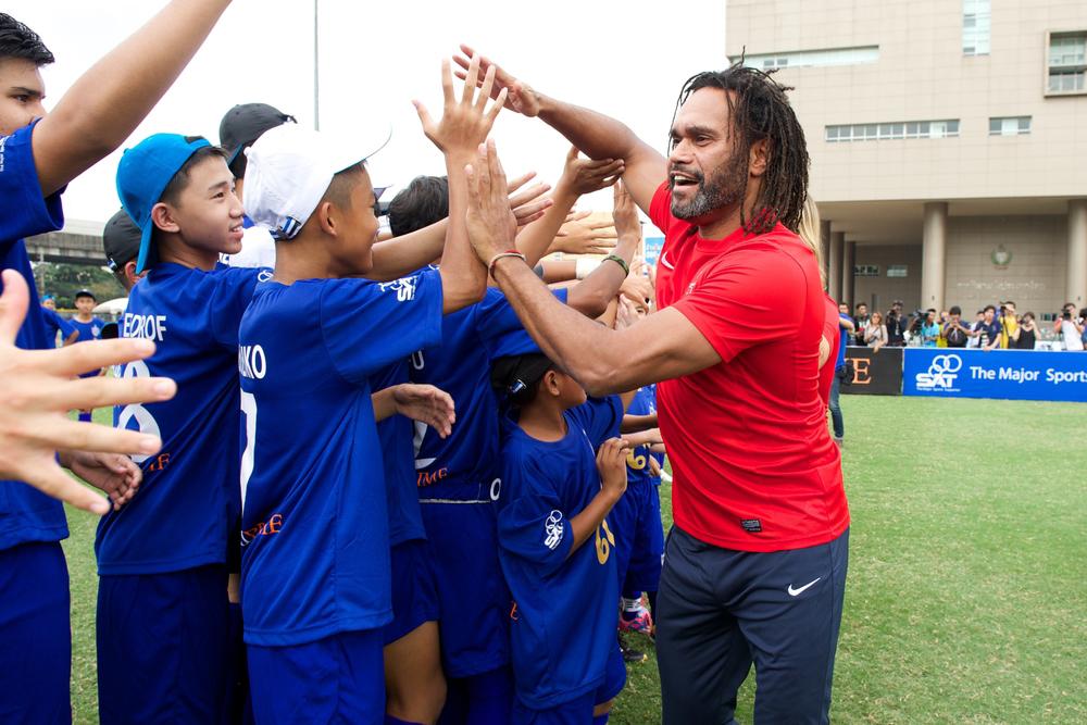 Coach high fiving young male sport team.