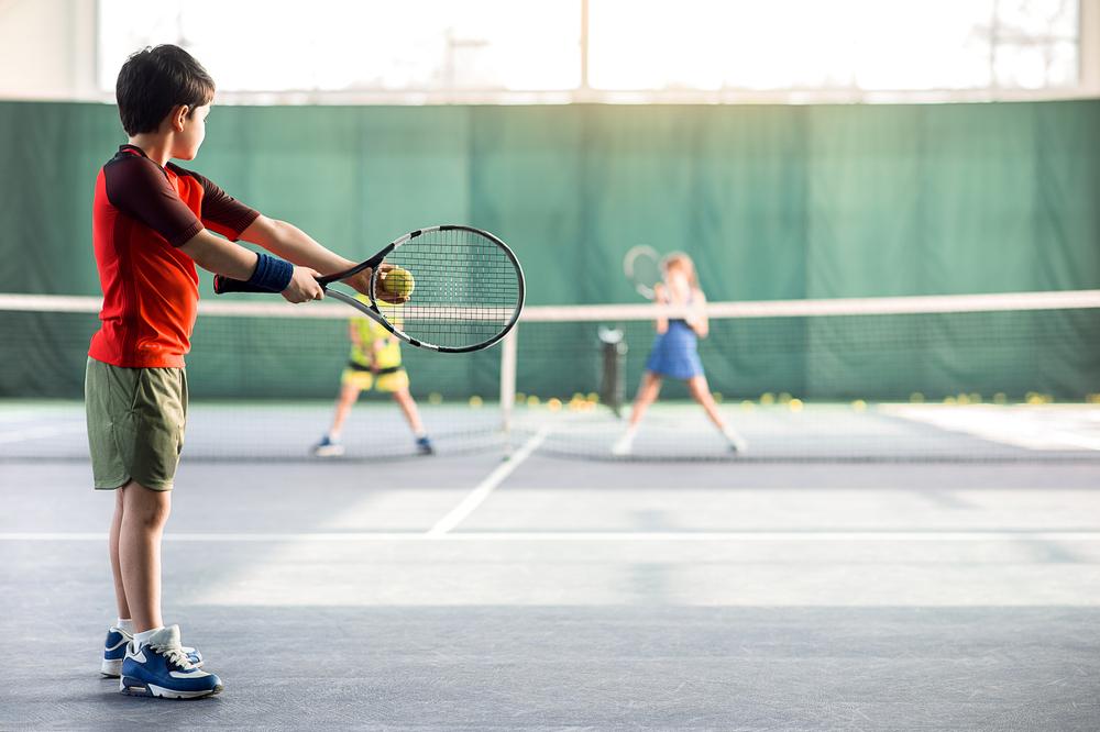 Young boy about to serve in tennis.