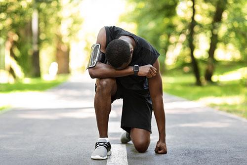 Tired runner kneeling.