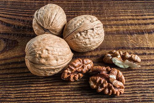 Close up of shelled and unshelled walnuts.