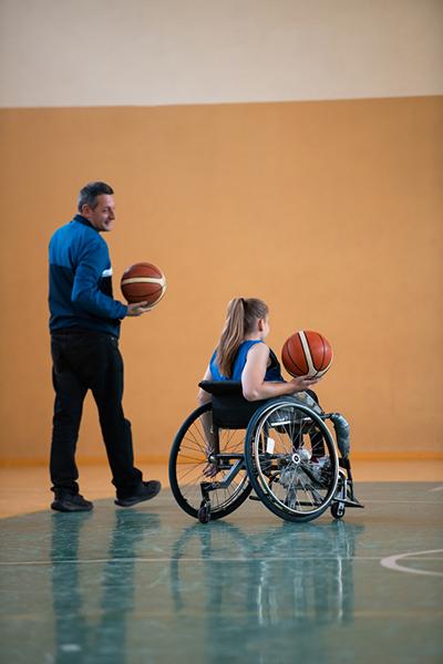 Coach with younger female wheelchair basketball player.