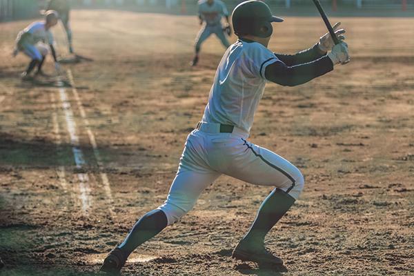 A young baseball player running after a hit.