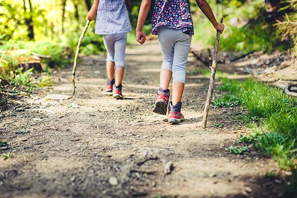 View from behind of two young girls hiking.