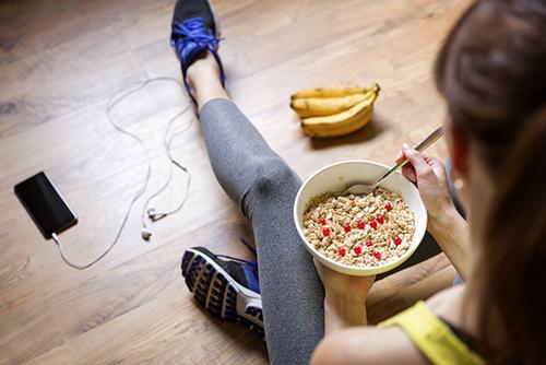 Young woman eating meal after a workout.